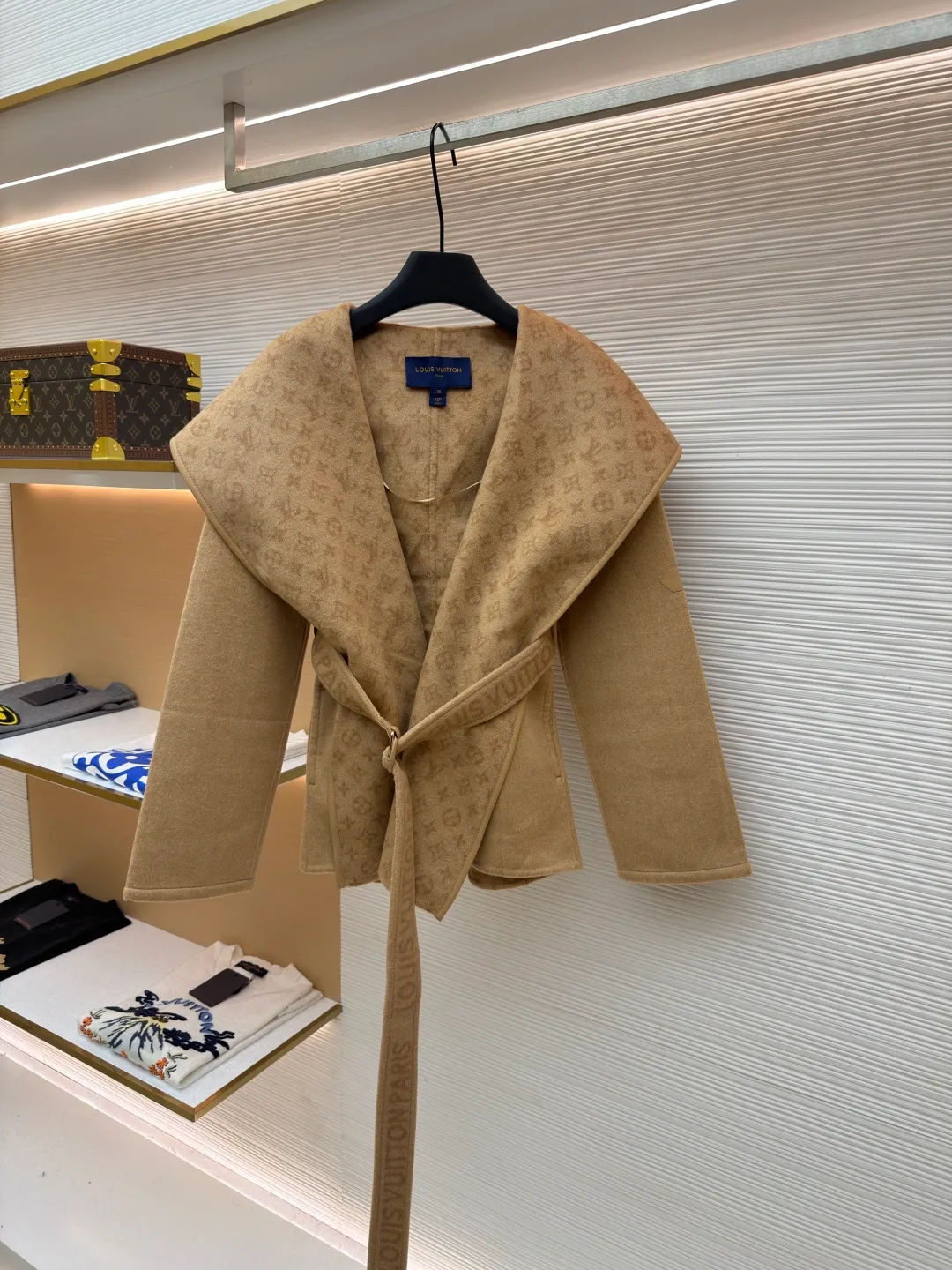 LOUIS VUITTON Wool lace-up wrap hooded coat (short style) ●Item number: 1682300-I45 ●Fabric: wool fabric ●Technology: jacquard production ●Color: khaki ●Version: loose fit ●Weight: about 1320 grams ●Size: 34-36-38-40 ●Description: This presbyopic wool coat is made of double-sided blended wool fabric imported from Italy. The main part is made of high-density matte black wool, which has been pre-shrunk and steam-set to ensure that the fabric is stiff and not easily deformed. The large lapel and belt areas use jacquard weaving technology to present the classic presbyopic pattern as a three-dimensional texture. The pattern is digitally positioned and plated to ensure that the texture is symmetrical and clear. The body of the garment is unlined and double-sided sewn to reduce the weight of the garment while improving skin-friendliness. The cuffs and hem are hand-stitched to reveal exquisite details. The waist is customized with a wide belt of the same fabric, with an adjustable buckle design with invisible stitching, allowing the silhouette to be freely adjusted; the neckline adopts a double-layer composite structure, combined with the fixation process of hand-made arch stitches, to make the large lapels more three-dimensional. Every splicing follows the precision sewing standard of 1cm/8 stitches, perfectly integrating craftsmanship and design aesthetics. The overall wiring is straight and delicate, the fabric is comfortable and soft, and the color is consistent without color difference. It can be matched with the same style to create a fashionable look and control various occasions. Customized accessories, complete with three standards, same style for men and women!